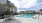 umbrella covered table and chairs next to swimming pool